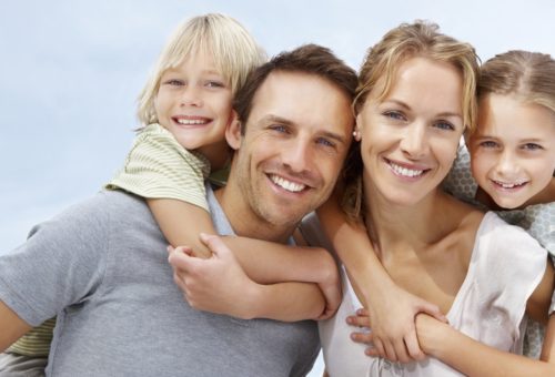 Portrait of a happy mature man and woman carrying kids on back